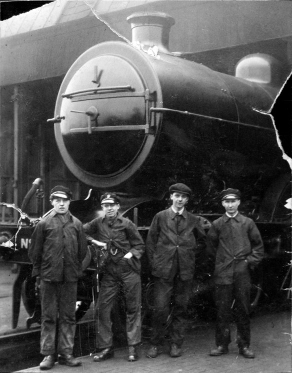 These locomotive cleaners are outside the 'new shed' with a well polished large Atlantic locomotive. The photograph is thought to have been taken around 1922. Left to right: unknown, unknown, Jack Bottomley, Wilf Gooch. Photograph lent by Boris Bennett; copied from an original print owned by Don Gooch, son of Wilf.
