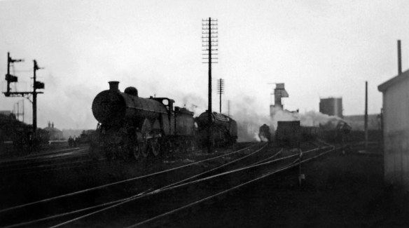Perhaps you can feel the stiff westerly breeze as it whips the smoke and steam almost horizontally across to the station on the left. The nearest locomotive is one of Grantham's large Atlantics, Edwardian express engines which, when this photograph was taken about 1949, were reaching the end of their working days. Photograph lent by Peter Wilkinson.